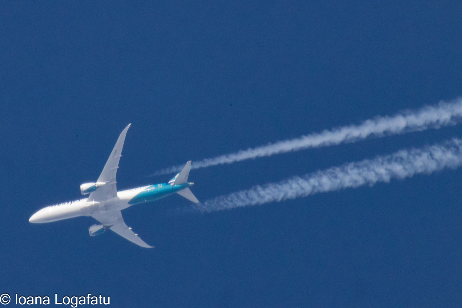 Boeing soaring high with trails against blue sky